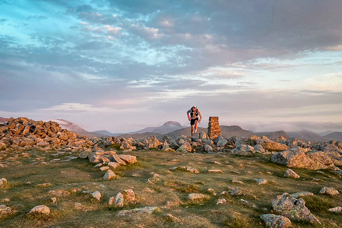 Pete running away from the trig point at the top of High Raise in the early morning light.