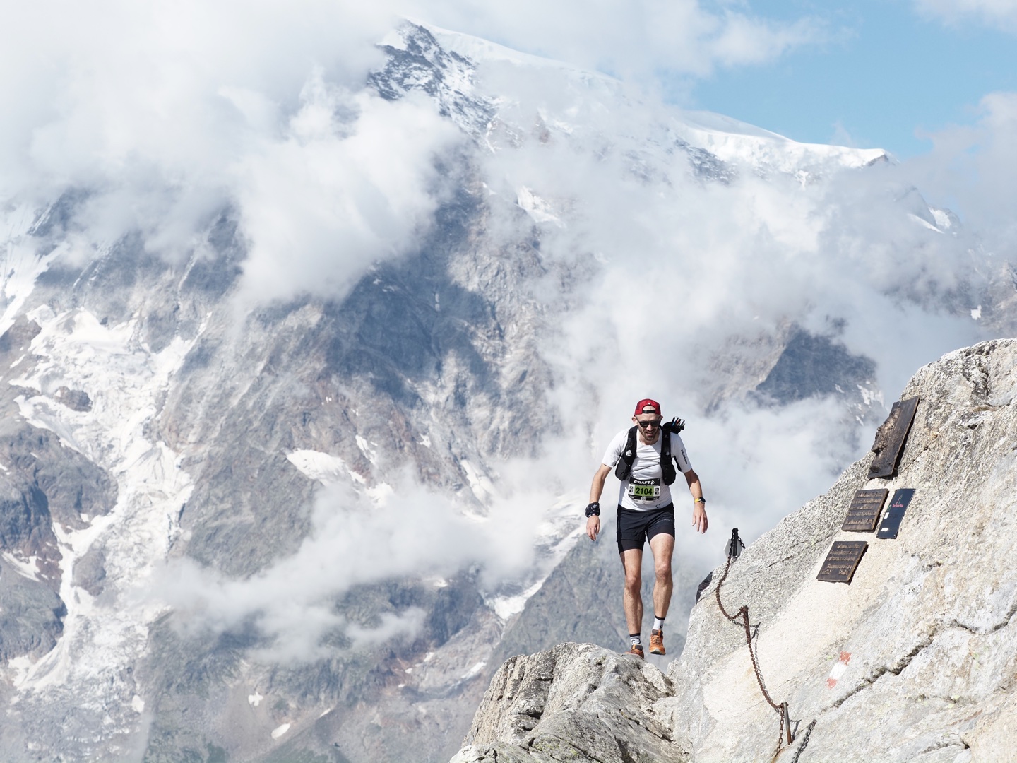 Pete crests Passo di Monte Moro, a high alpin pass, with the snowy slopes of Monte Rosa looming in the background.